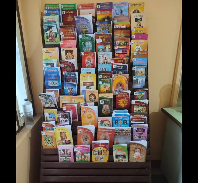 Complete book collection at Swasti Prakashan — 90+ titles displayed on book rack